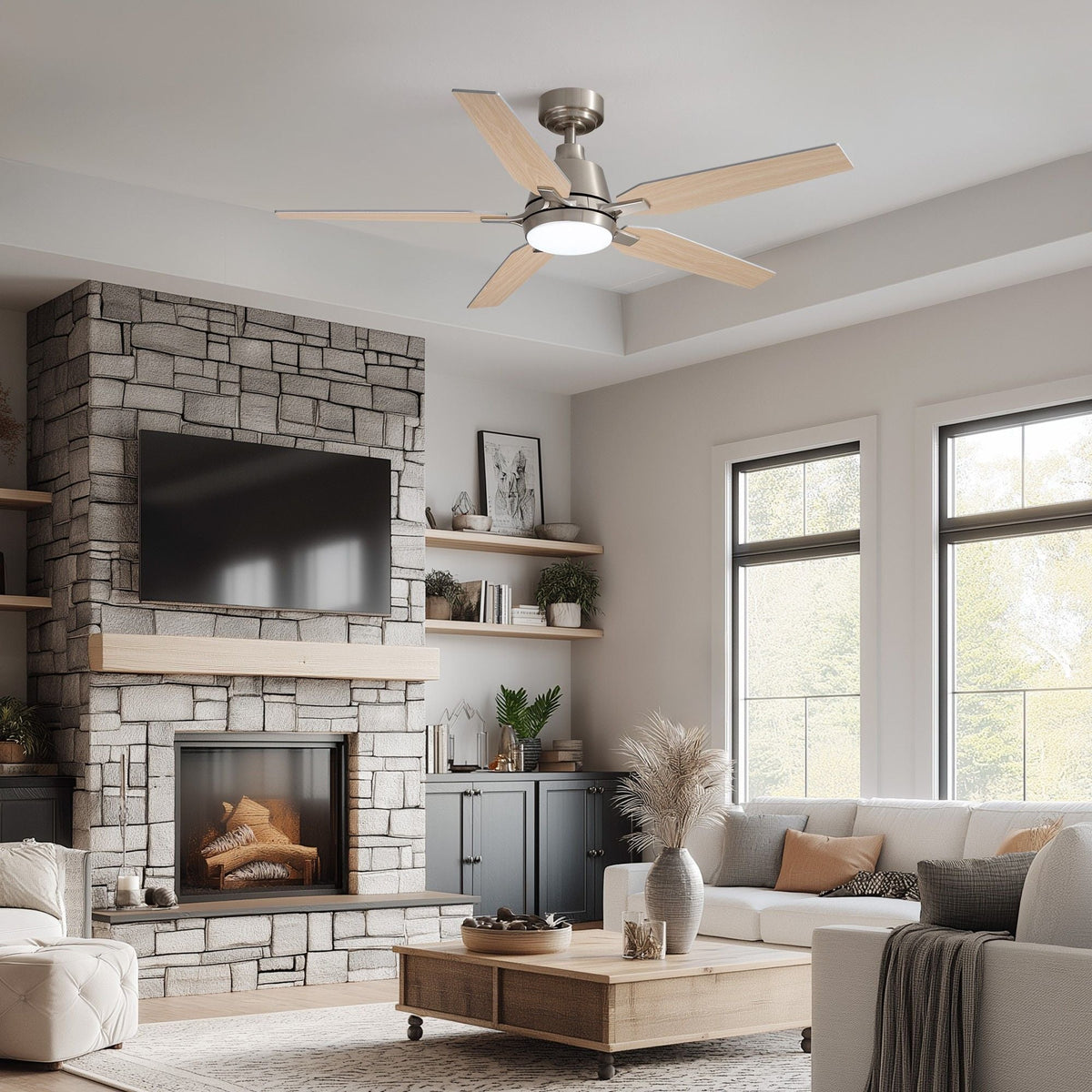 Brushed nickel ceiling fan in modern farmhouse living room — stone fireplace, wall TV, white sofa, wooden coffee table, large windows, warm LED glow | CARRA HOME