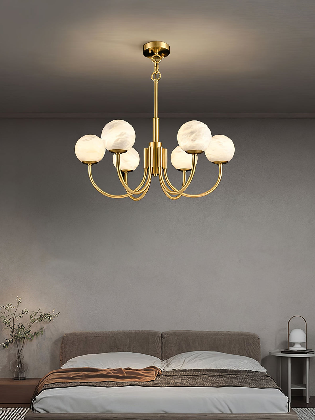Gold alabaster globe chandelier above a bedroom seating area | CARRA HOME