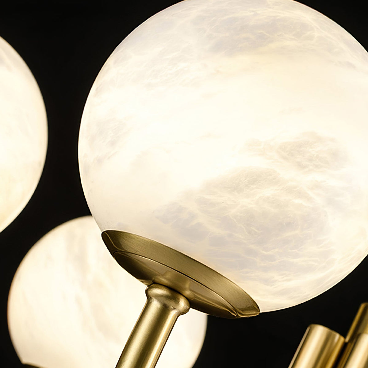 Natural alabaster veining and gold globe connection detail | CARRA HOME
