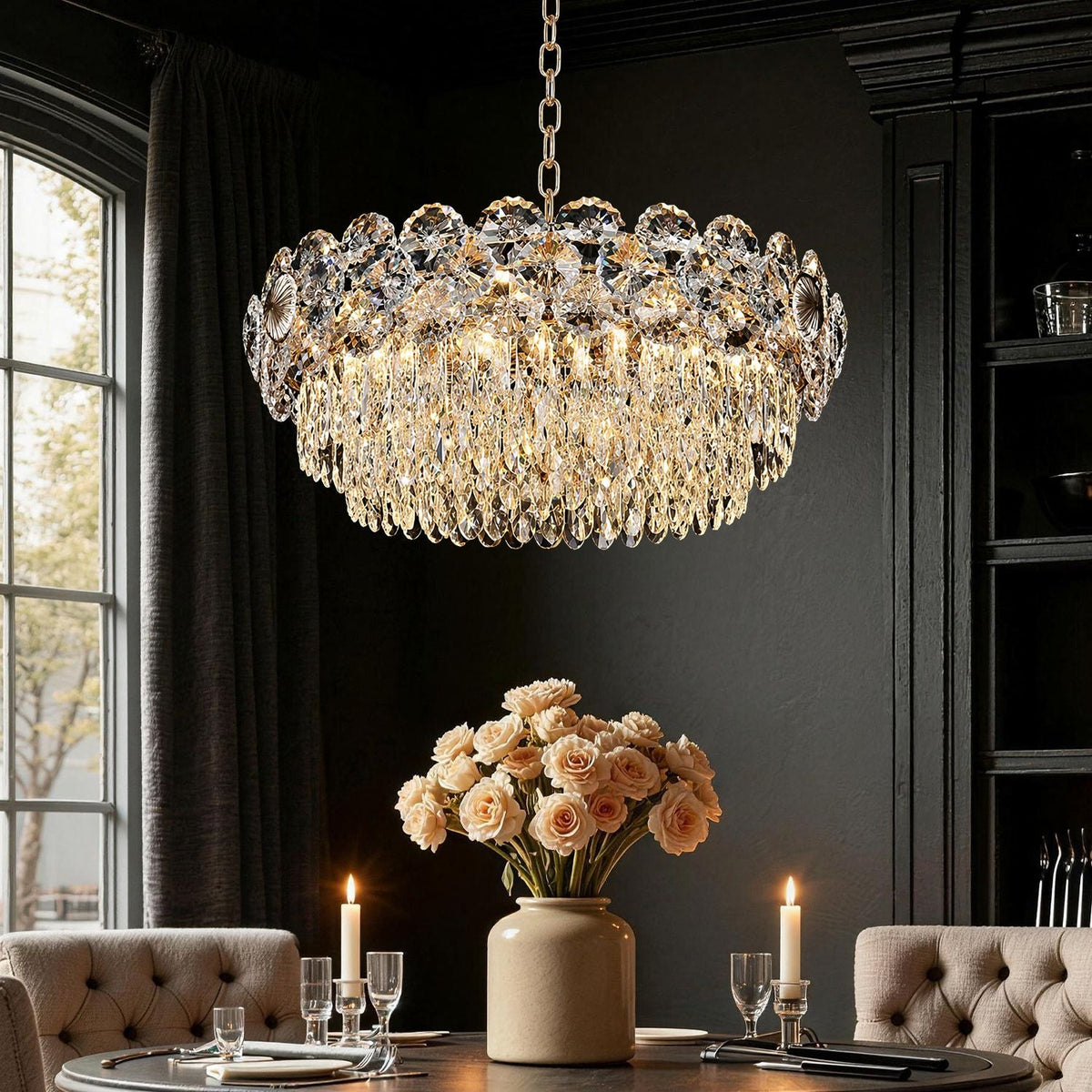 Glacia Modern Luxury Staggered K9 Crystal Flush Mount Chandelier in a dining room — hanging above a round table with pink flowers, candles, and elegant tableware, against a dark paneled wall | Carra Home