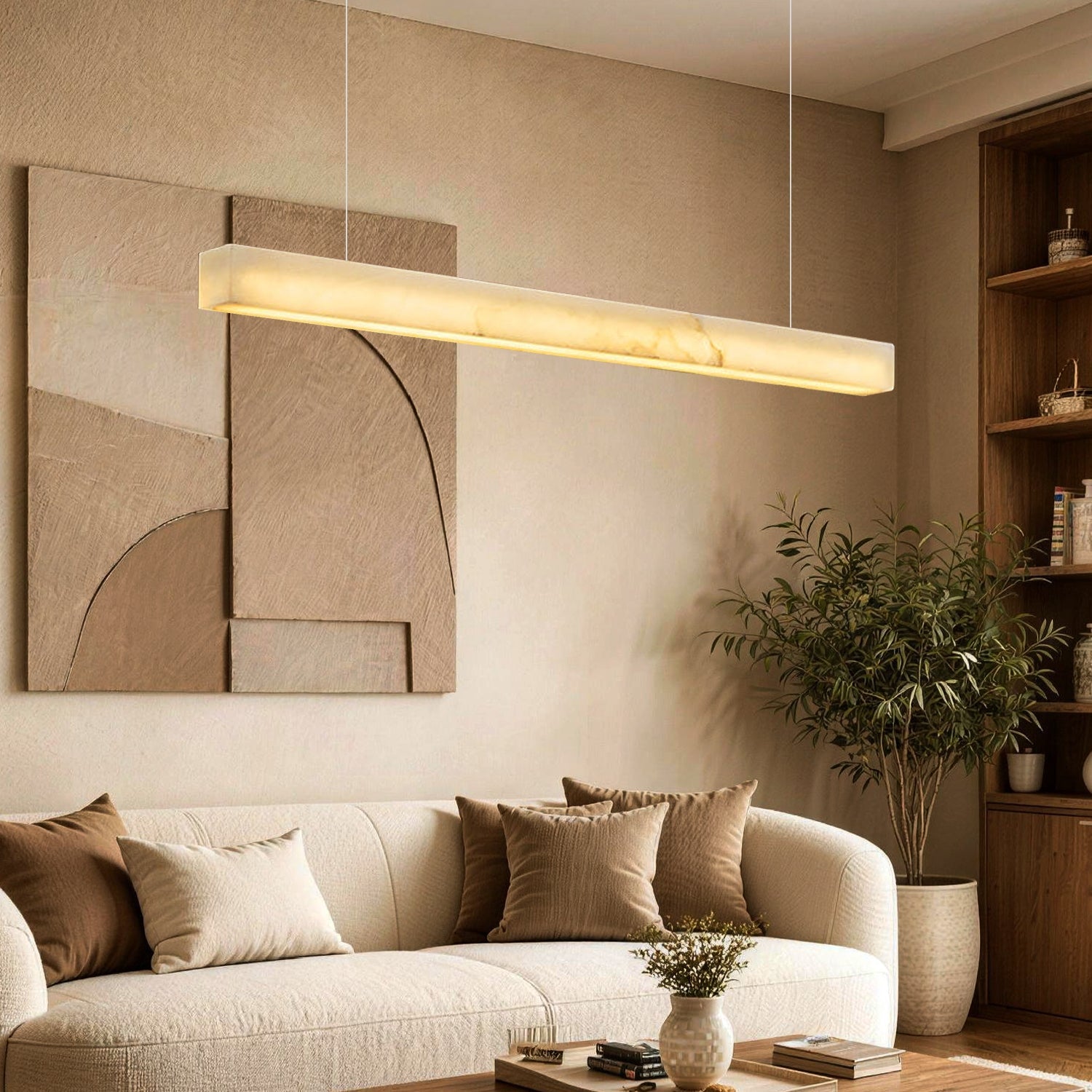 Horizon Modern Minimalist Alabaster Ultra-Slim Linear LED Chandelier in a living room — illuminating a beige sectional sofa with earth-toned pillows, a dark wood coffee table, and abstract wall art -carra-home