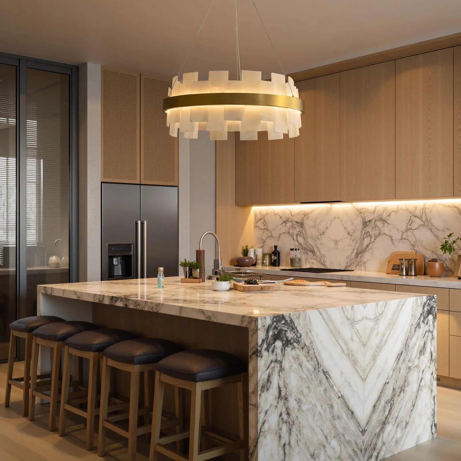 modern-round-alabaster-gold-chandelier-with-layered-alabaster-panels-and-central-gold-band-hanging-above-marble-kitchen-island-with-warm-ambient-light-carra-home