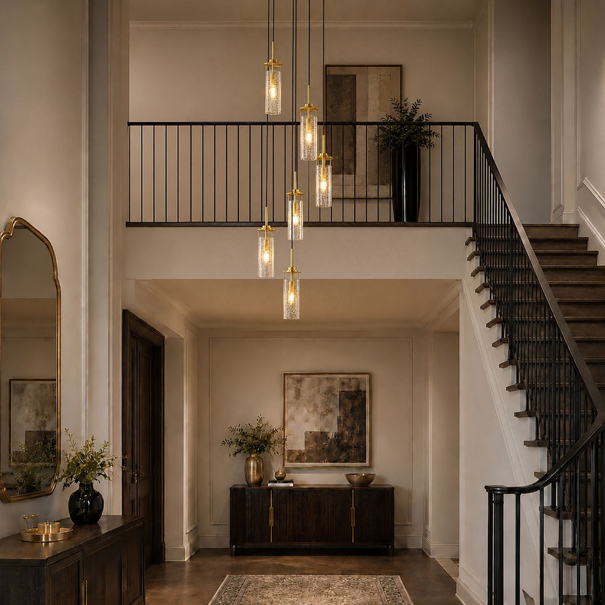 Novera Chandelier suspended over staircase — black wrought iron railing, double-height ceiling, natural light — enhances vertical drama and sophistication | Carra Home