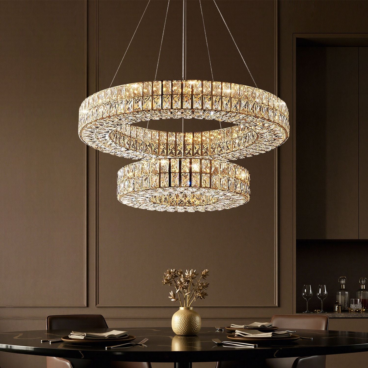 Selene Crystal Double-Ring Chandelier illuminating a formal dining table — beige tufted chairs, dark wood table, and elegant floral centerpiece under warm golden glow | Carra Home