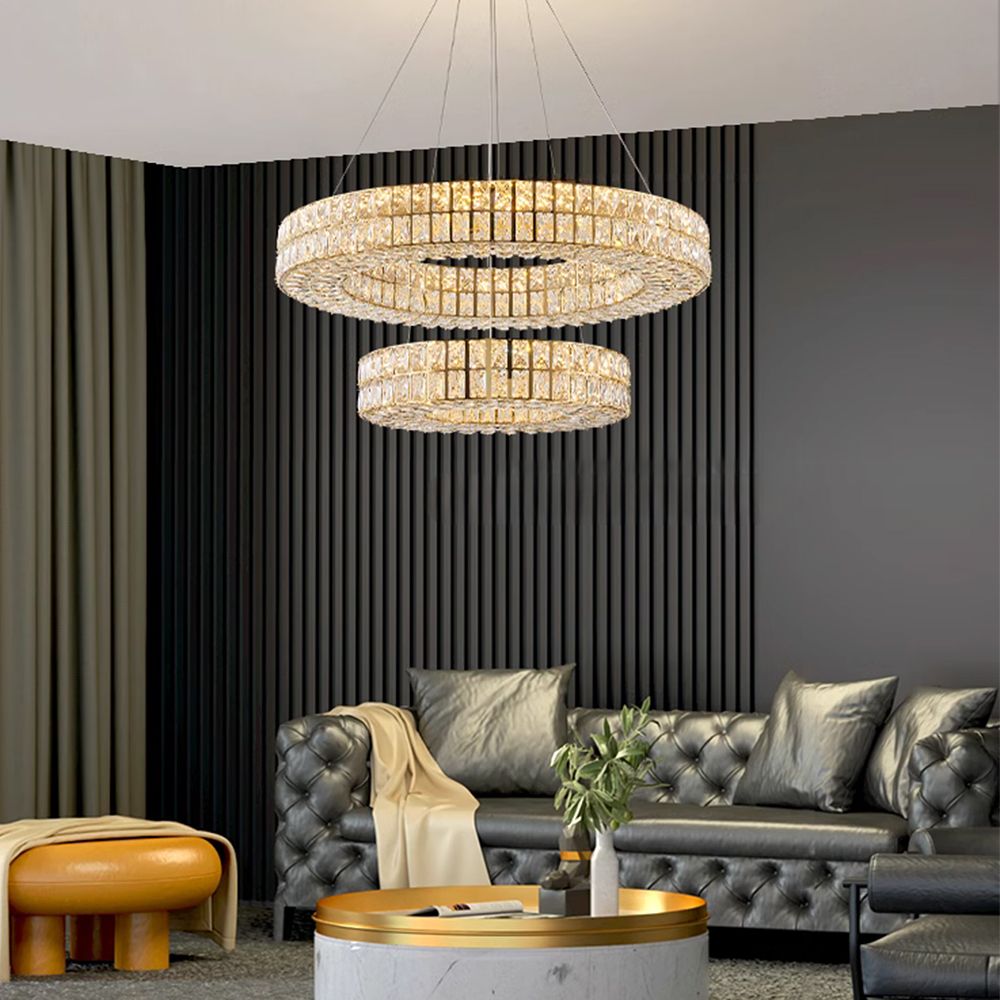 Selene Crystal Double-Ring Chandelier in a chic living space — gray velvet sofa, marble coffee table, vertical wood paneling, and layered textures under crystal radiance | Carra Home
