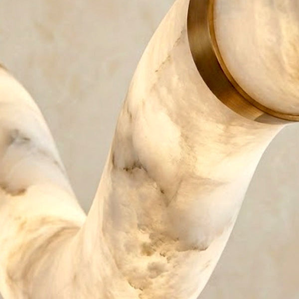 Close view of an alabaster tube and gold connector joint | CARRA HOME