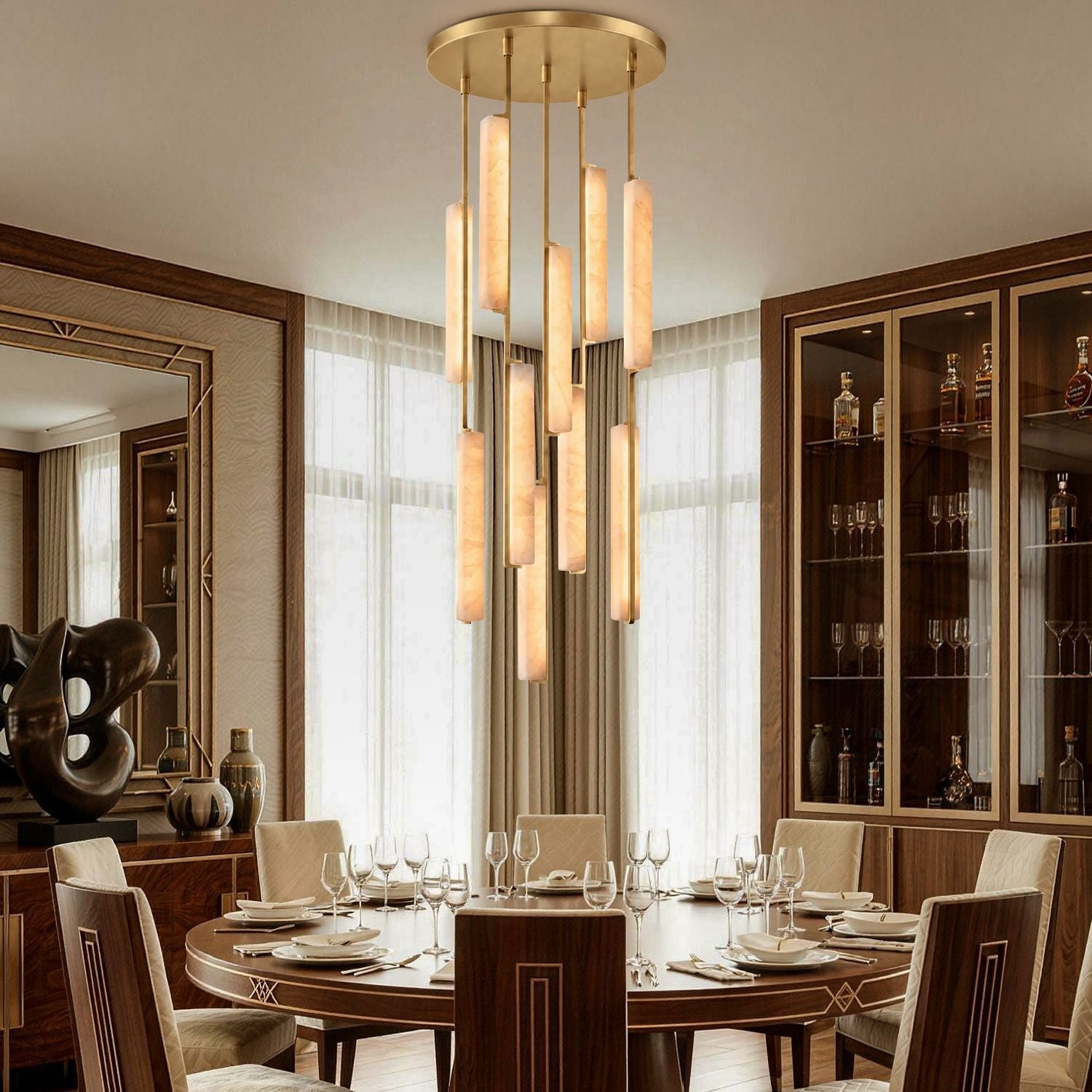 Stamen Modern Minimalist Alabaster Vertical Chandelier in a dining room — hanging above a round wooden table set for fine dining, with glass cabinets and elegant tableware in the background-carra-home