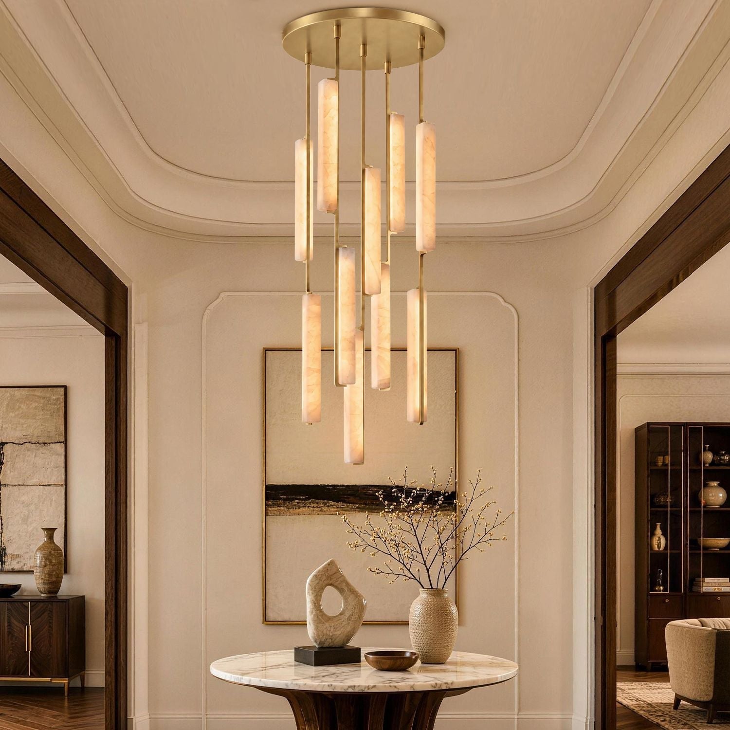 Stamen Modern Minimalist Alabaster Vertical Chandelier in a living room — hanging above a beige sectional sofa with abstract art and elegant decor, showcasing vertical alabaster rods with gold accents-carra-home