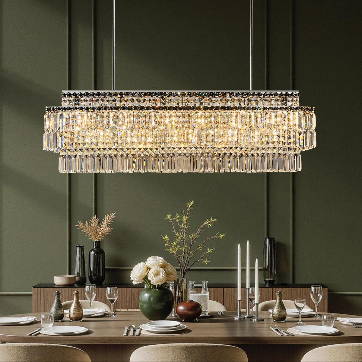 Stellar Grand Linear Silver Multi-Faceted K9 Crystal Chandelier in a dining room — hanging above a marble table with white flowers, elegant tableware, and a dark paneled wall backdrop | Carra Home