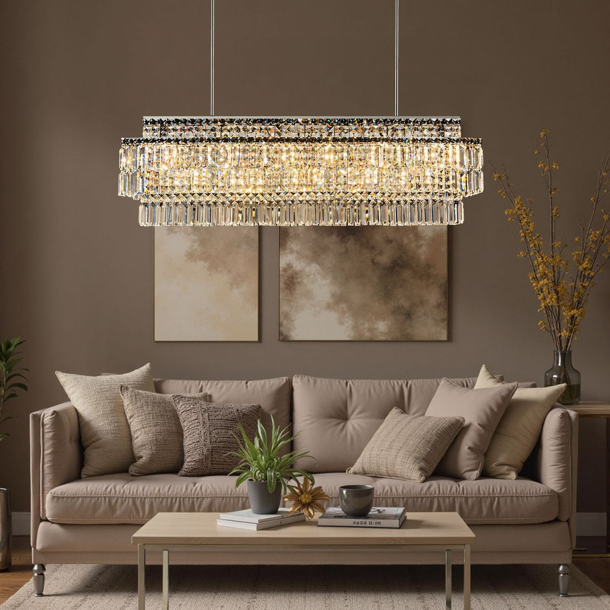 Stellar Grand Linear Silver Multi-Faceted K9 Crystal Chandelier in a living room — hanging above a black velvet sofa with decorative pillows, a marble coffee table, and dark paneled walls | Carra Home