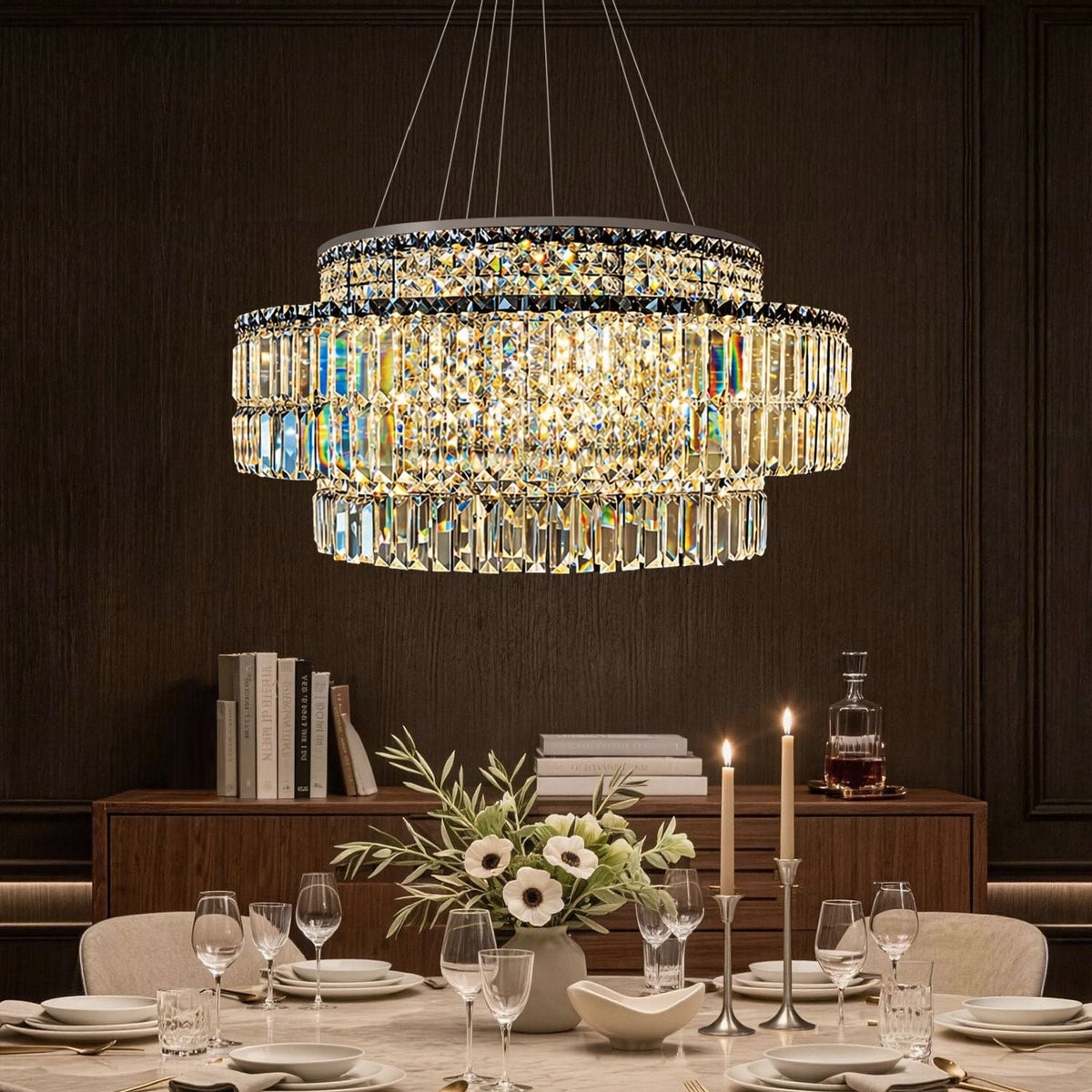 Stellar Modern Silver Multi-Faceted K9 Crystal Round Chandelier in a dining room — hanging above a marble table with white flowers, elegant tableware, and a dark paneled wall backdrop | Carra Home