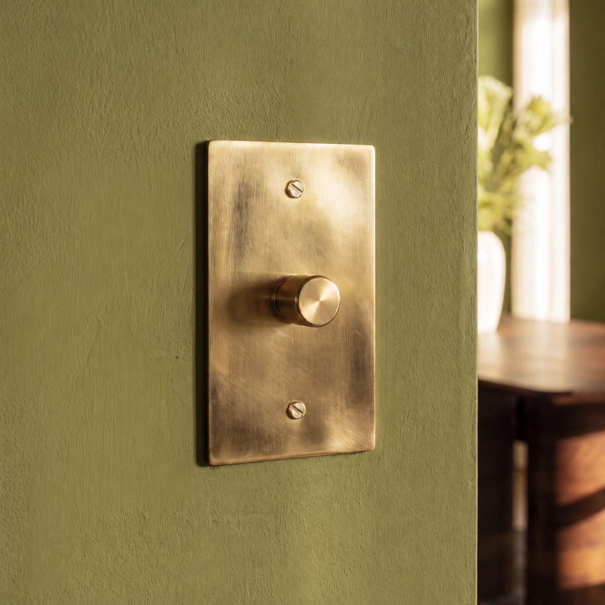 Unlacquered Brass Dimmer Switch installed in an interior, view 9 — seamless faceplate | CARRA HOME