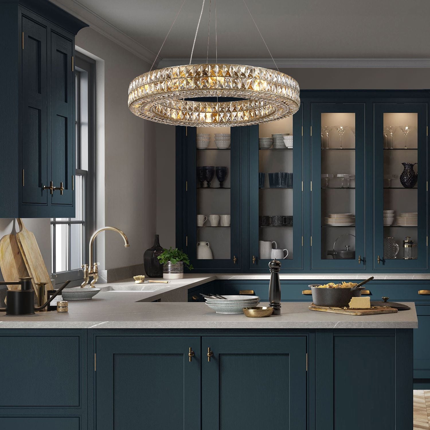 Valdore Chandelier over a modern kitchen island — navy cabinetry, marble countertop, brass fixtures | Carra Home