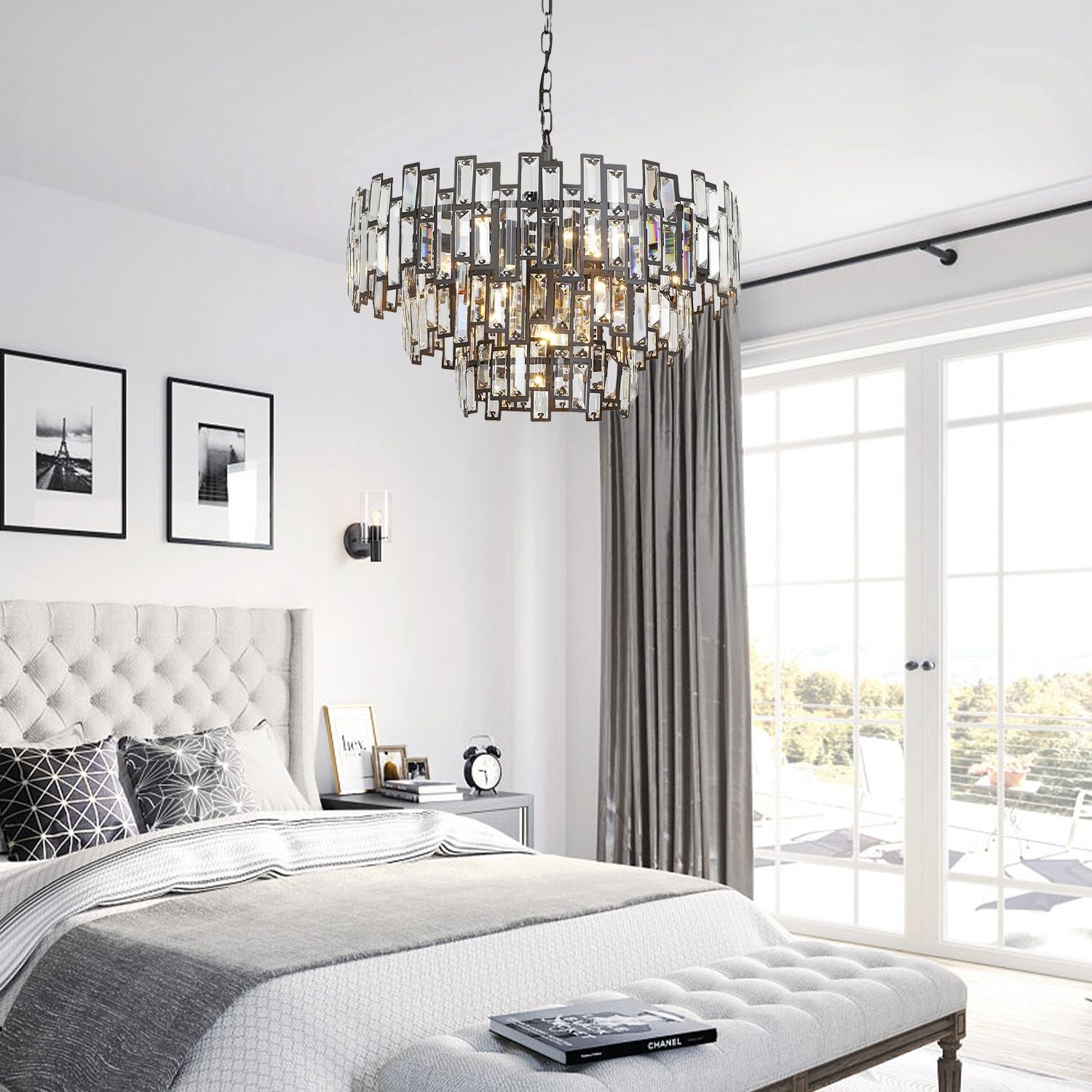 Vera Crystal Prism Tiered Chandelier in a contemporary bedroom — hanging above a bed with patterned pillows, white walls, and minimalist decor | Carra Home