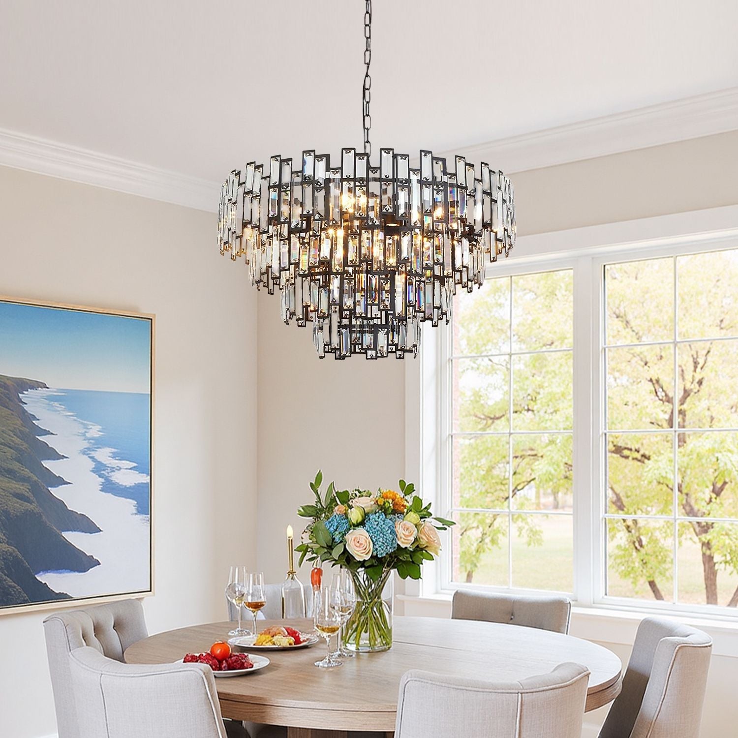 Vera Crystal Prism Tiered Chandelier in a coastal-style dining room — suspended above a round table with blue accents, large windows, and light gray walls | Carra Home