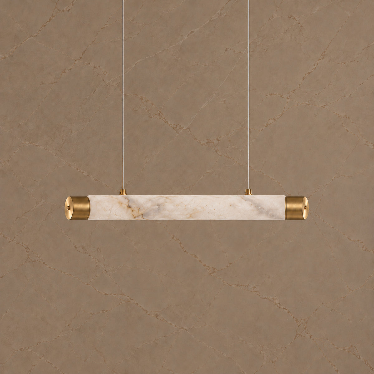Virel Alabaster Linear Chandelier — Gold 100 cm alabaster tube chandelier switched off against the same marble wall | CARRA HOME