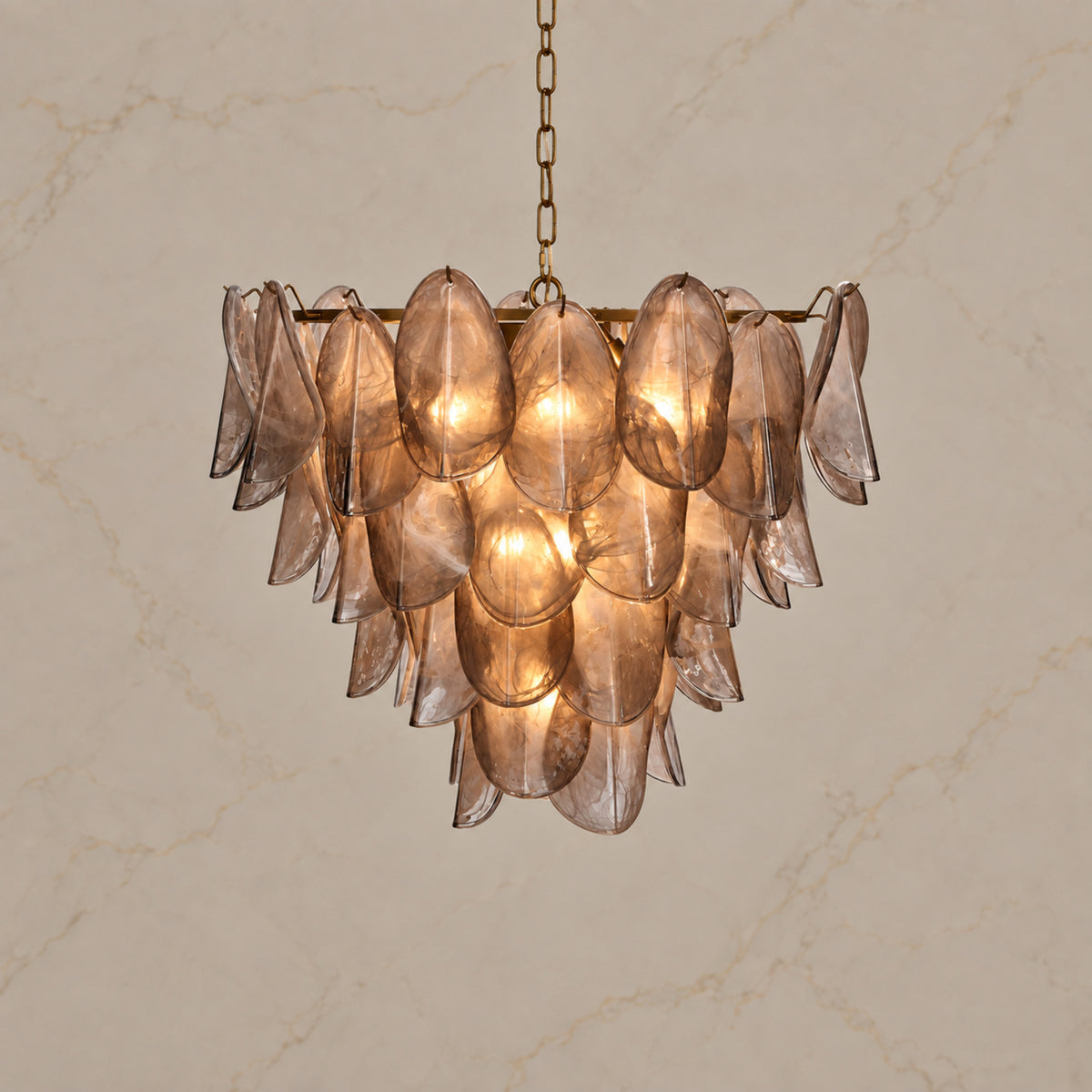 Magnolia taupe glass petal chandelier illuminated on warm greige stone | CARRA HOME