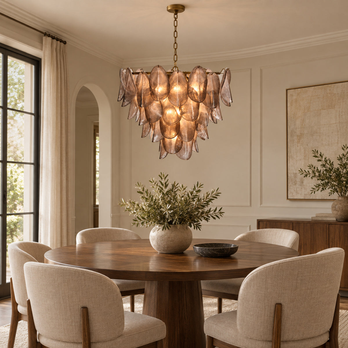 Magnolia taupe glass petal chandelier above a round dining table | CARRA HOME