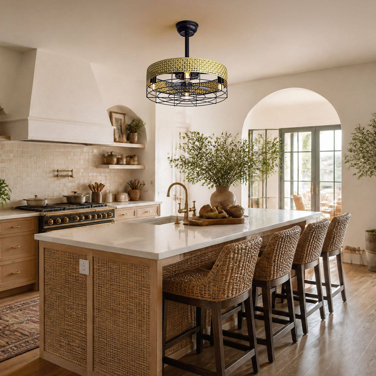 Boho woven ceiling fan over kitchen island — white countertop, woven bar stools, arched window, warm kitchen natural light | CARRA HOME