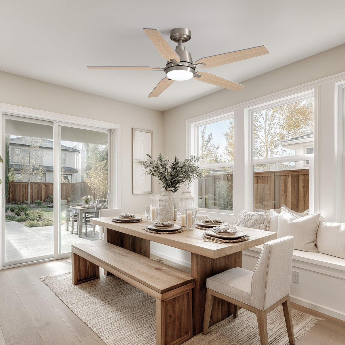 Smart ceiling fan in bright dining room — solid wood table, bench seating, white chairs, sliding glass door to backyard, natural light, cozy farmhouse decor | CARRA HOME