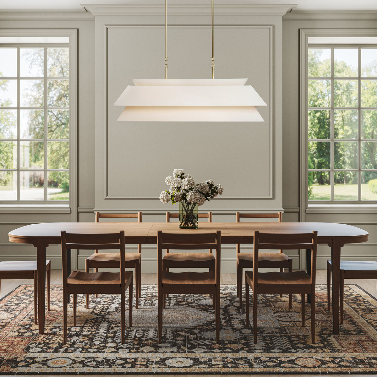Ainsley layered chandelier above a long wood table in a paneled dining room | CARRA HOME