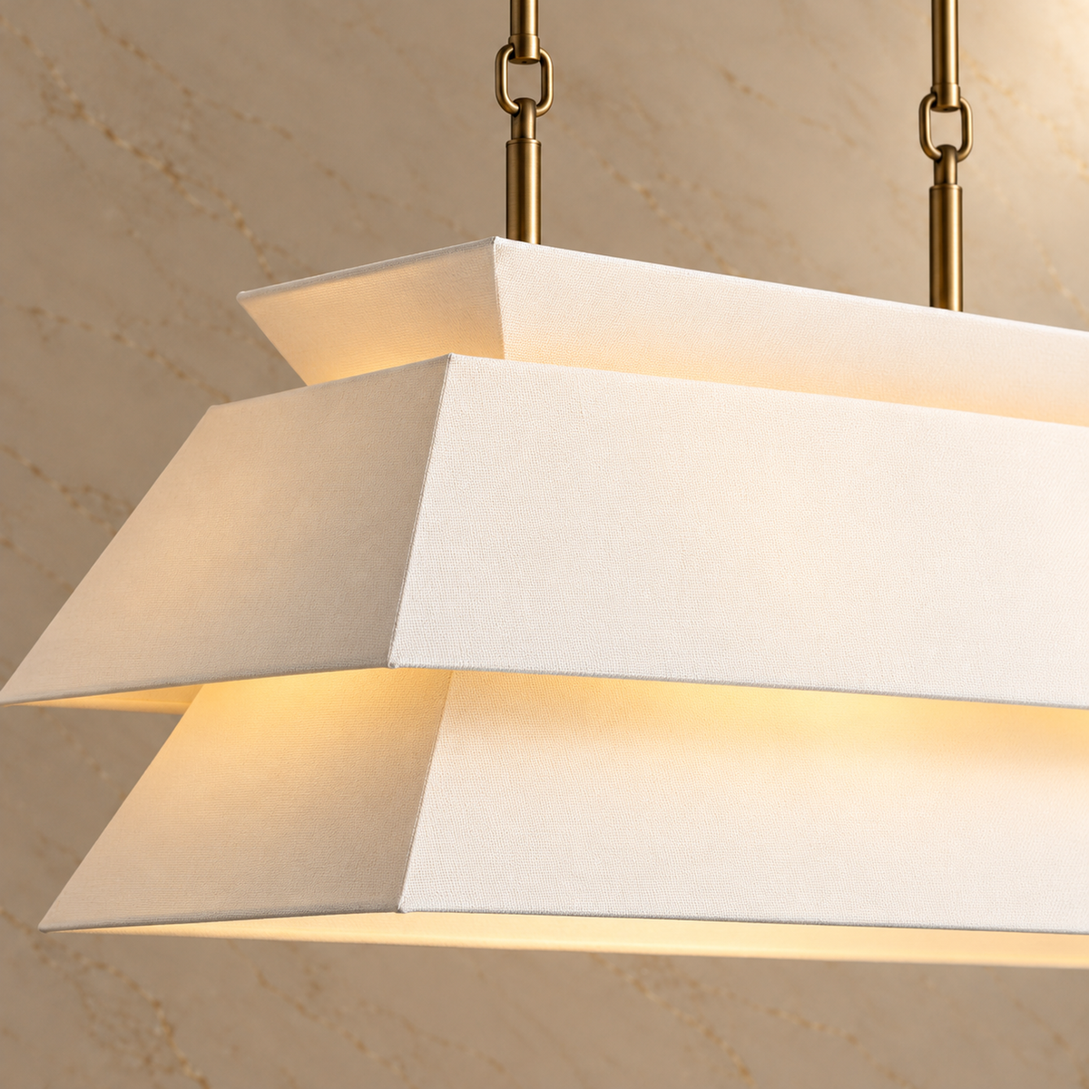 Layered white fabric planes and antique brass suspension joint detail | CARRA HOME