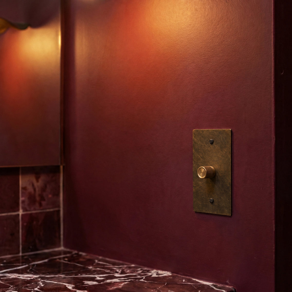 Brass Rotary Dimmer Switch installed in an interior, view 45 — seamless faceplate | CARRA HOME