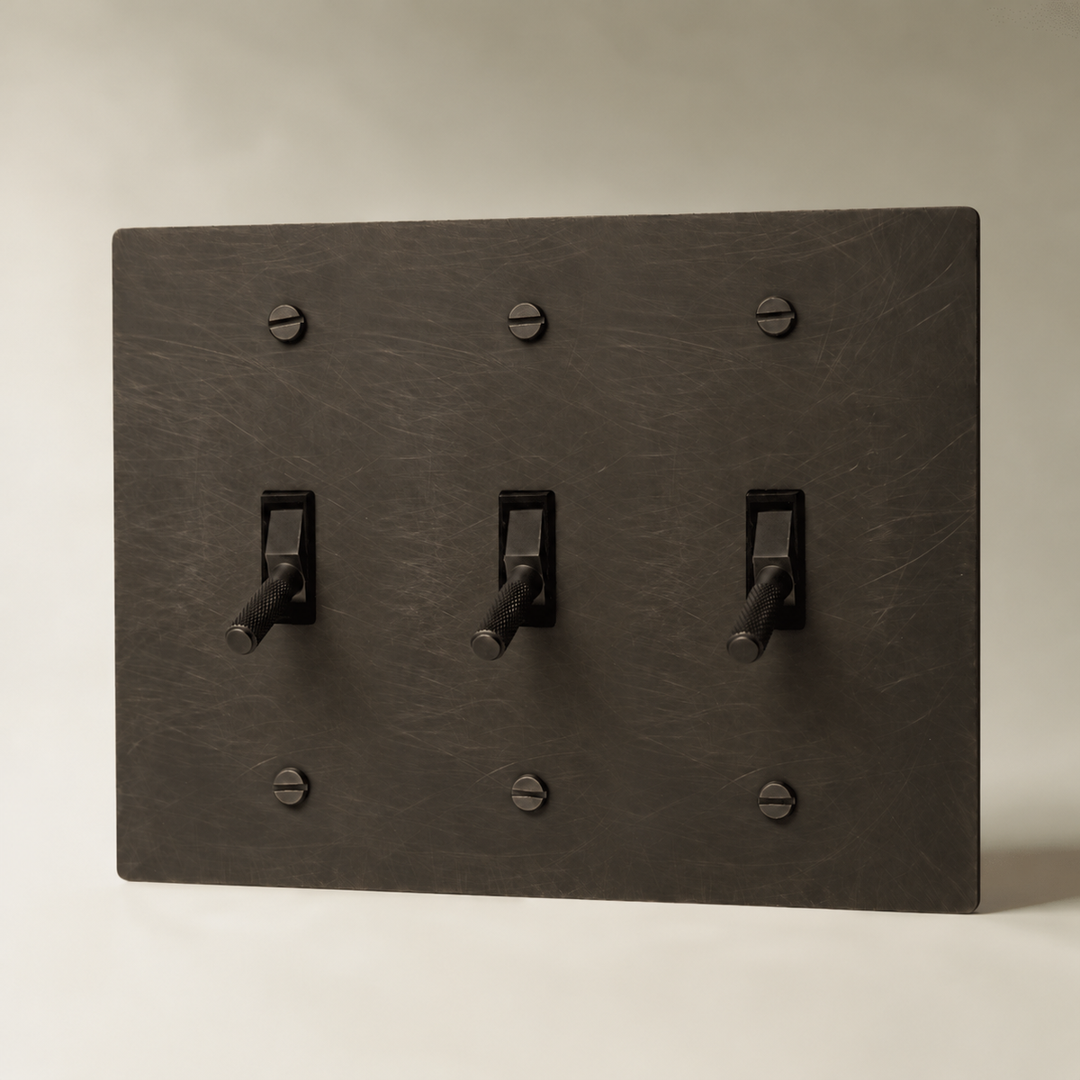 Brass Toggle Switch, Bronze with Patina 3 Gang product view — seamless faceplate | CARRA HOME