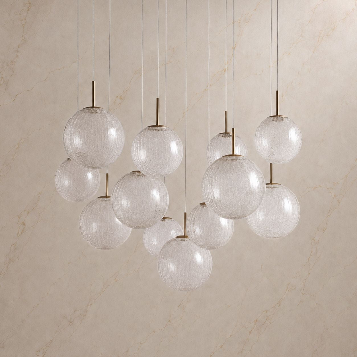 Casen Sculptural Chandelier unlit — clear textured glass spheres, minimalist brass hardware, and elegant suspension cables against neutral wall for daytime aesthetic | Carra Home
