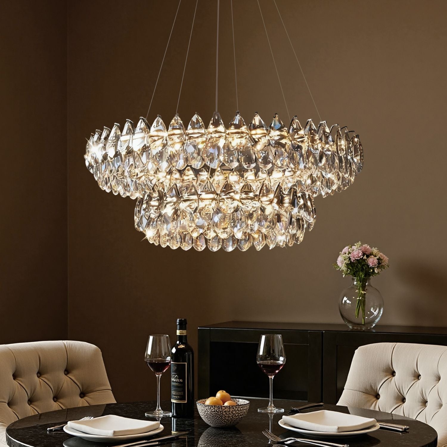 Crystal Dual Tier Water Drop Chandelier illuminating a modern dining table — beige upholstered chairs, dark wood table, and elegant centerpiece under warm ambient glow | Carra Home