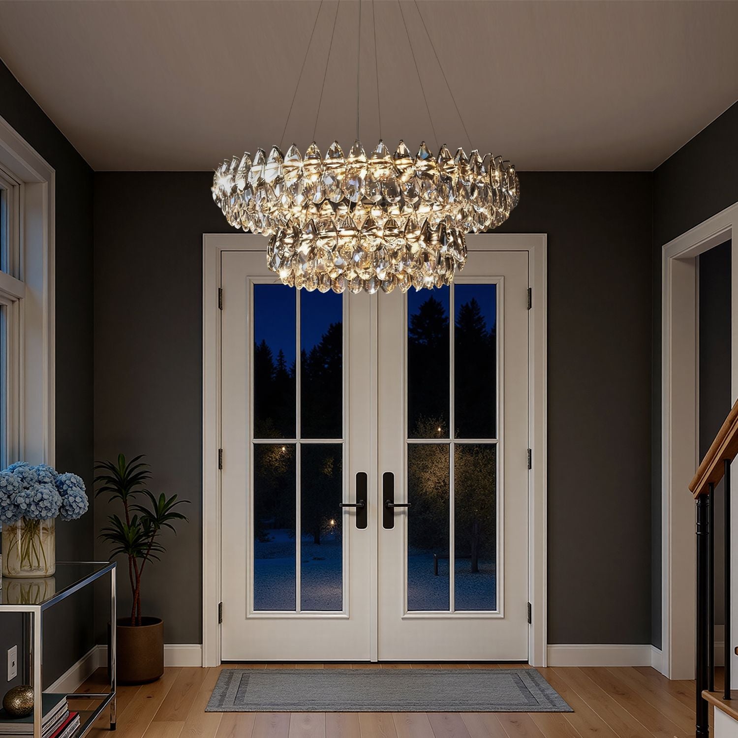 Crystal Dual Tier Water Drop Chandelier in a grand foyer — white double doors, dark walls, potted greenery, and welcoming evening glow | Carra Home
