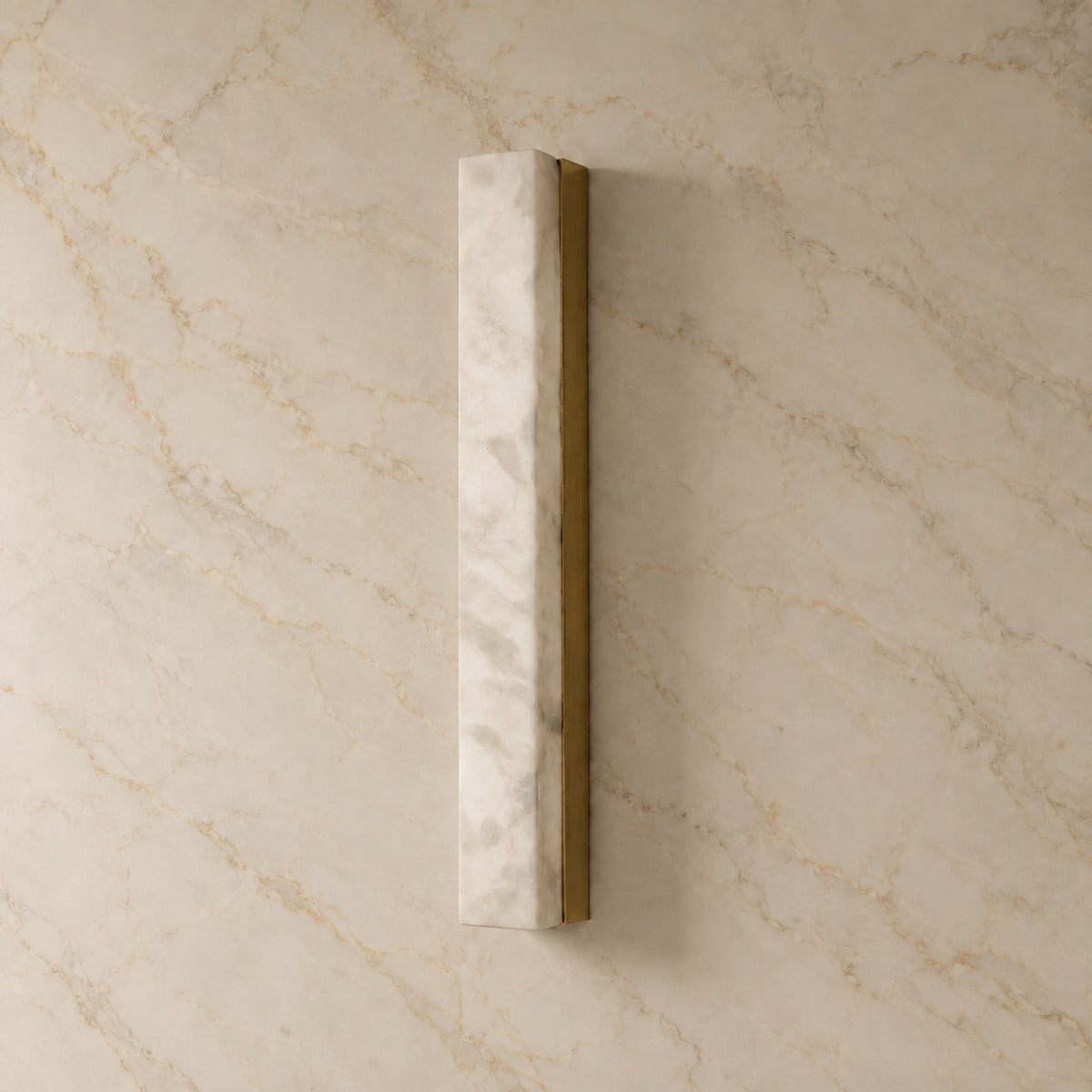 Dara Alabaster Linear Wall Sconce with gold hardware, switched off, on a marble wall | CARRA HOME