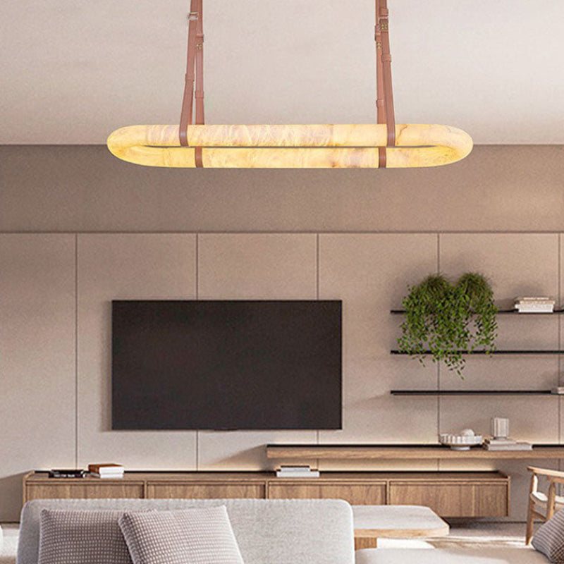 Gold leather oval alabaster chandelier in an open kitchen and living area | CARRA HOME