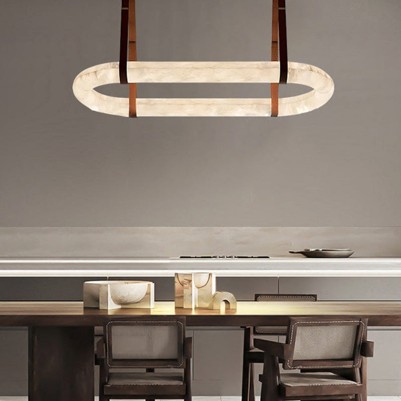 Gold leather oval alabaster chandelier above a modern kitchen island | CARRA HOME