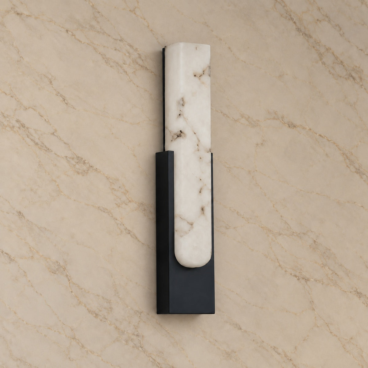 Emilia Alabaster Wall Sconce with black hardware, switched off, on a marble wall | CARRA HOME