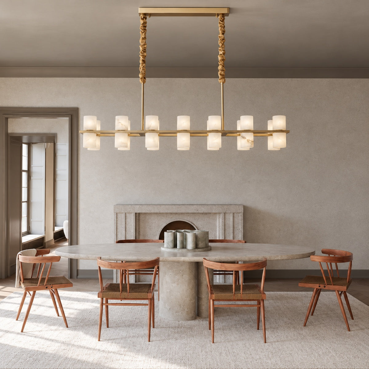 Gold alabaster cylinder chandelier above a dining table | CARRA HOME