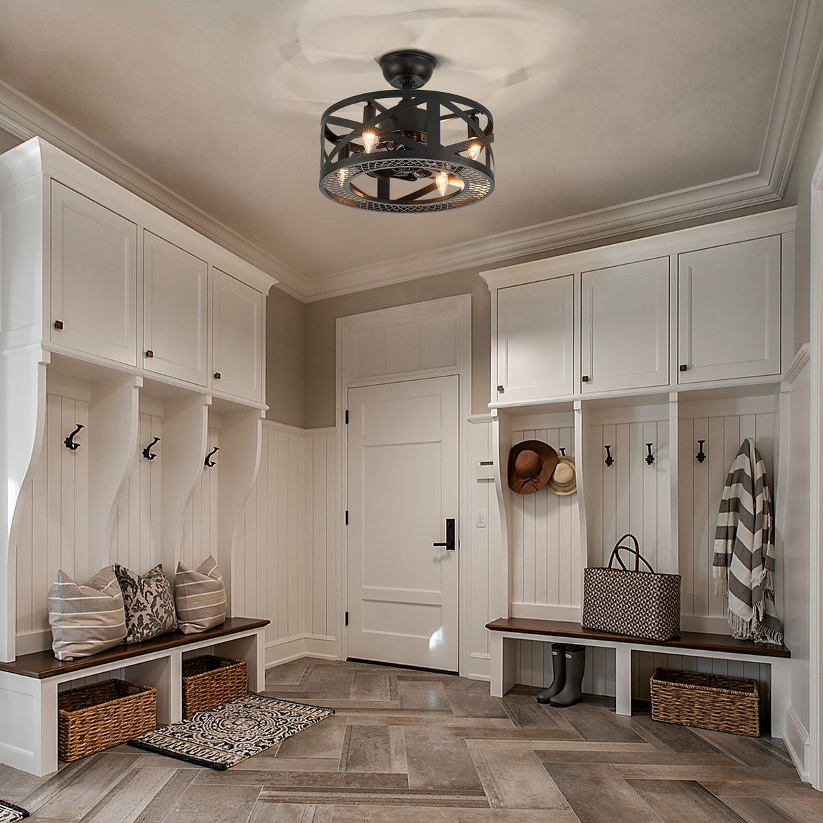 Modern caged ceiling fan in farmhouse mudroom/entryway — white built-in cabinets, hooks, benches with baskets, warm rustic lighting | CARRA HOME