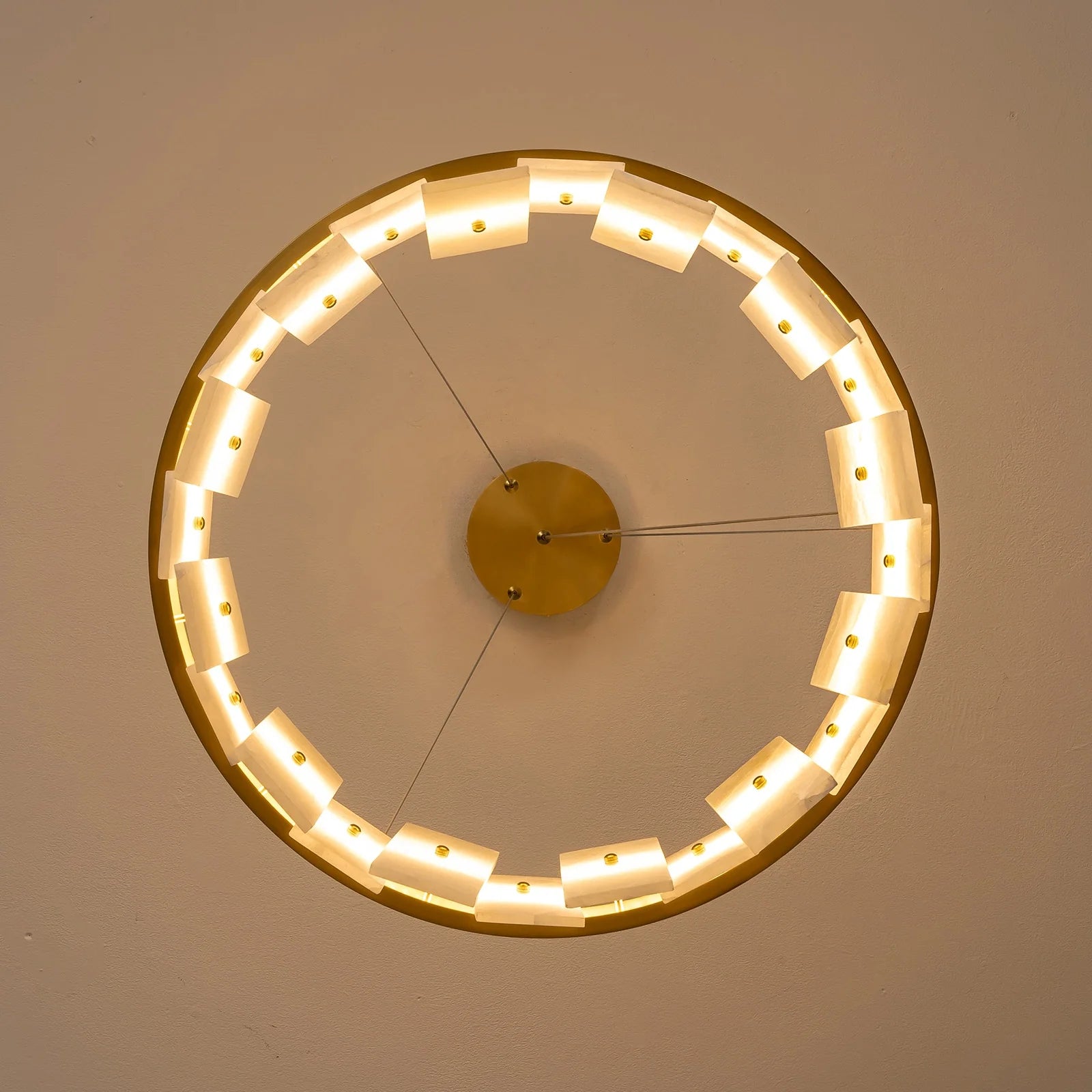 underside-view-modern-round-alabaster-gold-chandelier-with-circular-gold-frame-and-evenly-spaced-alabaster-panels-emitting-warm-light-carra-home