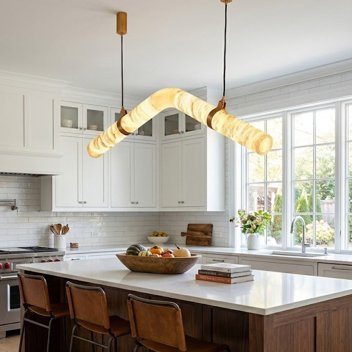Curved alabaster tube chandelier above a kitchen island | CARRA HOME