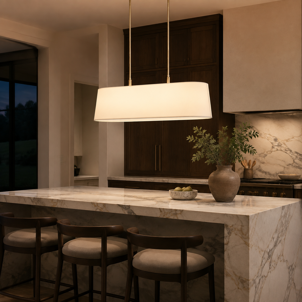 Stark Metal Linear Chandelier in gold above a marble kitchen island