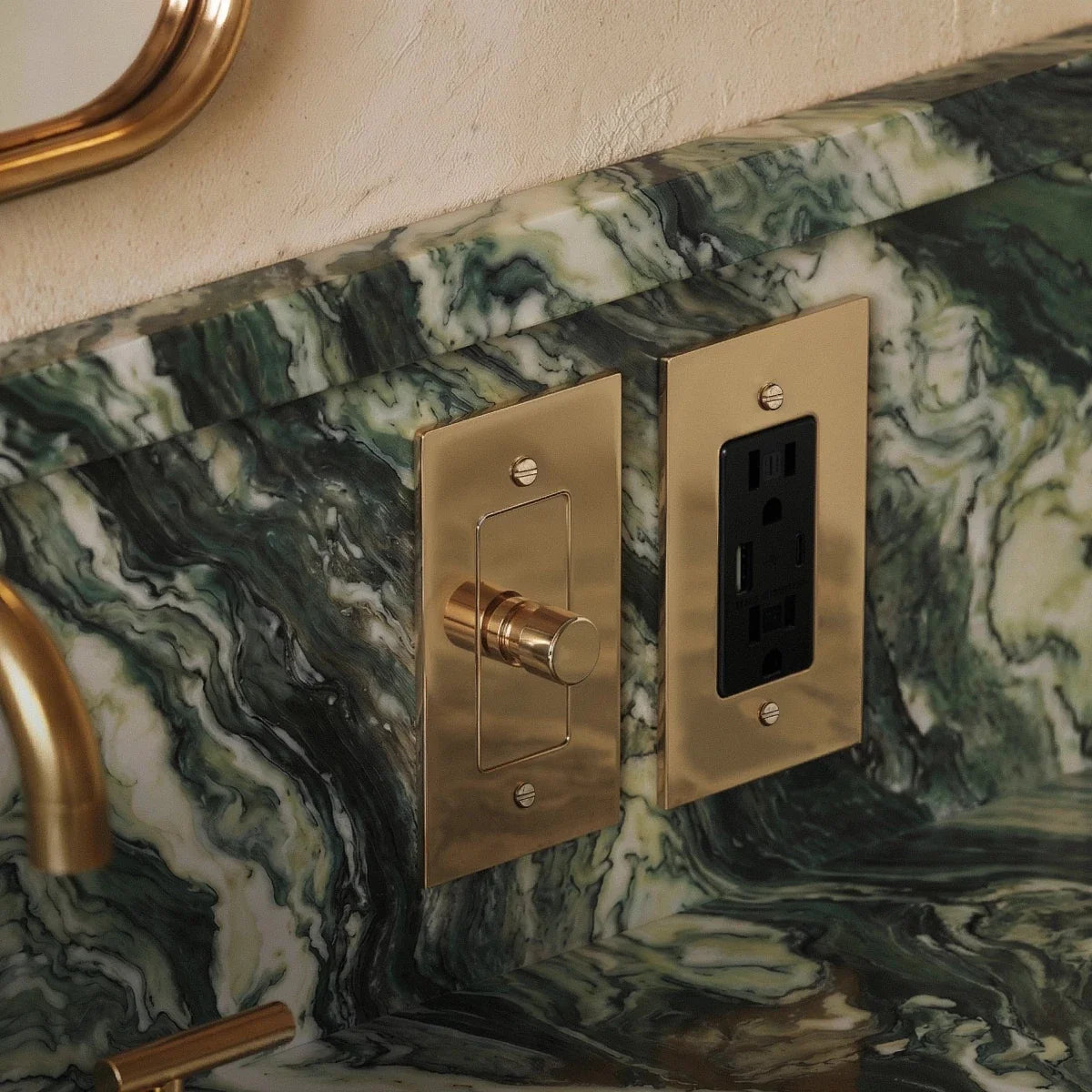 The Polished Brass Outlet — polished brass dimmer and Black Standard outlet on green marble | CARRA HOME