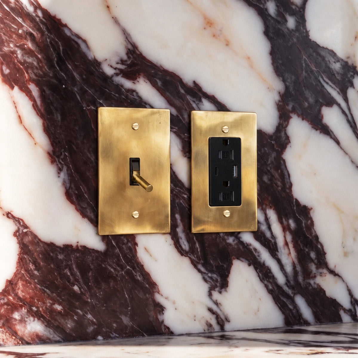 Unlacquered Brass Toggle Switch with seamless brass faceplate installed in an interior, view 7 | CARRA HOME