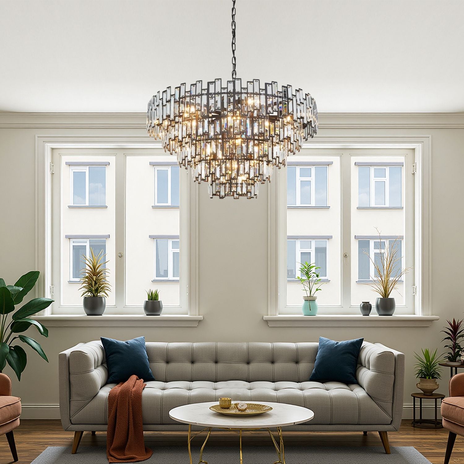 Vera Crystal Prism Tiered Chandelier in a modern living room — hanging above a beige tufted sofa, red area rug, and floor-to-ceiling windows | Carra Home